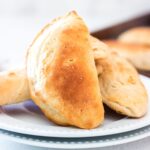 Finished empanadas being served on a plate.