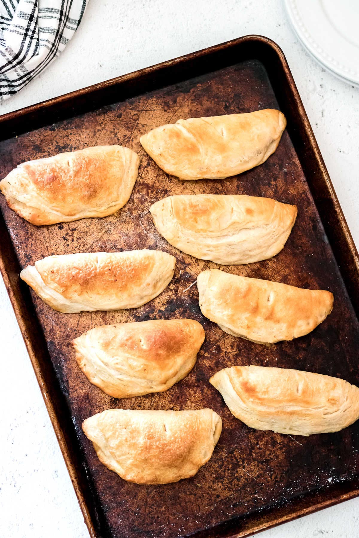 Finished empanadas on a baking sheet.