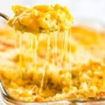 Serving of gooey macaroni and cheese being removed from the dish.
