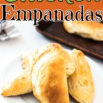 Chicken empanads on a plate with a text overlay for Pinterest.