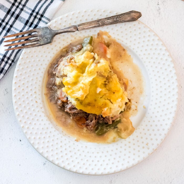 Overhead view of a serving of shepherd's pie on a white plate.