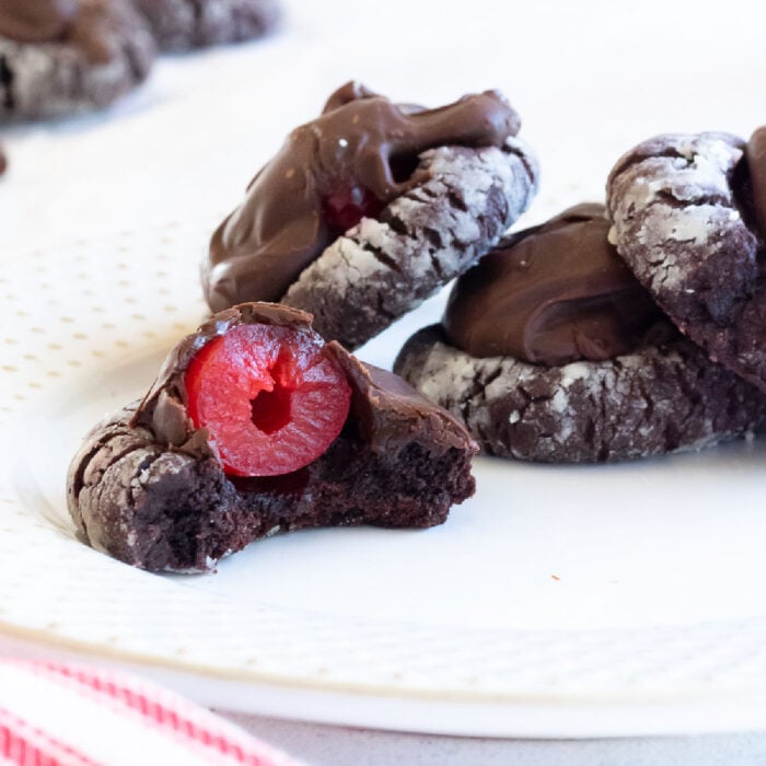 Closeup of chocolate covered cherry cookies on a white plate.
