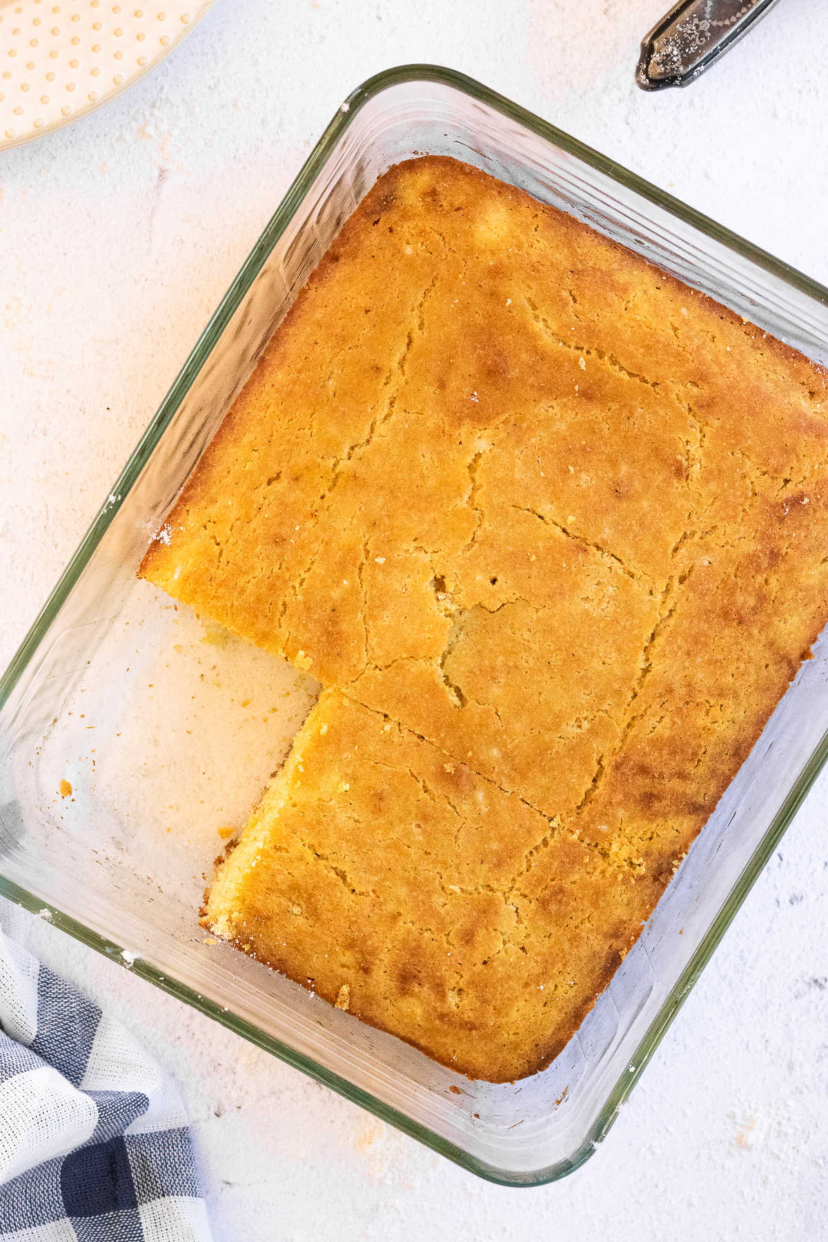Overhead view of baked cornbread with a serving removed