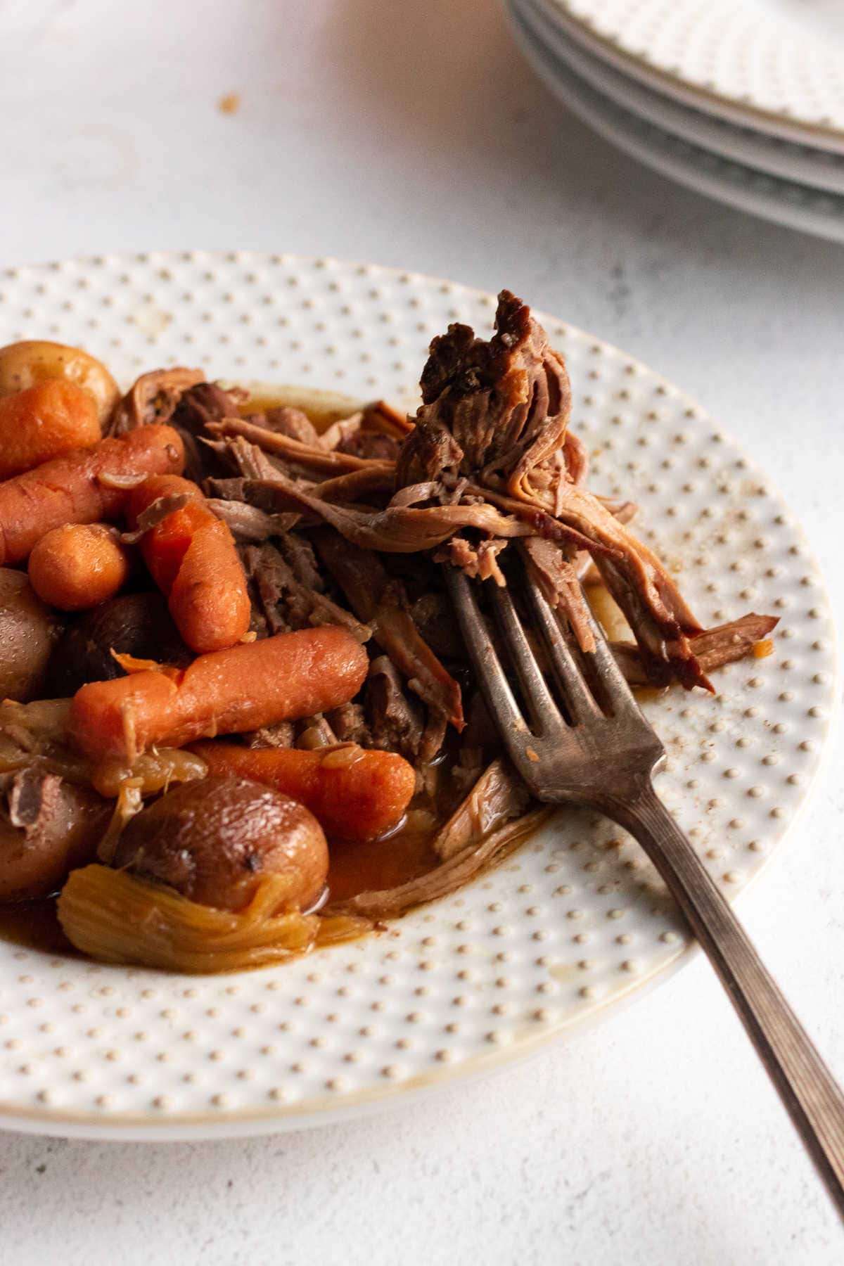 Forkful of beef on a plate.