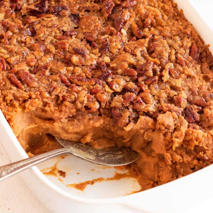 Close up of sweet potato crunch casserole with a serving removed from dish.