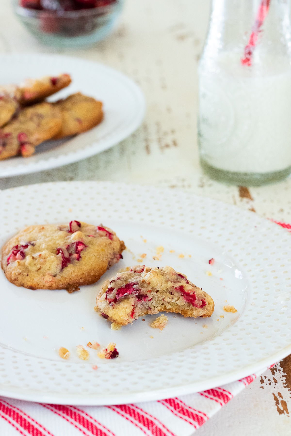 Cookies on a plate with a glass of milk to the side.