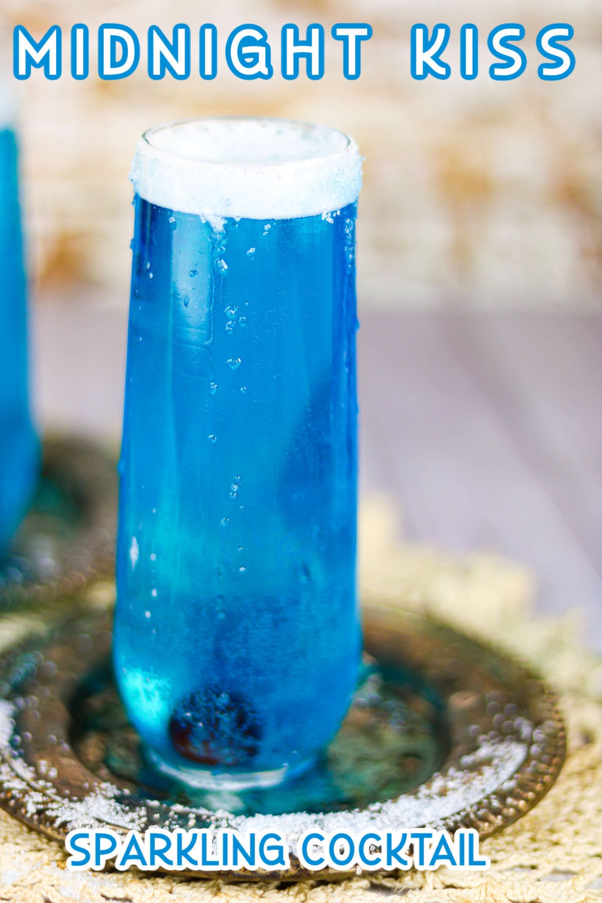 Blue sparkling cocktail in a champagne flute.
