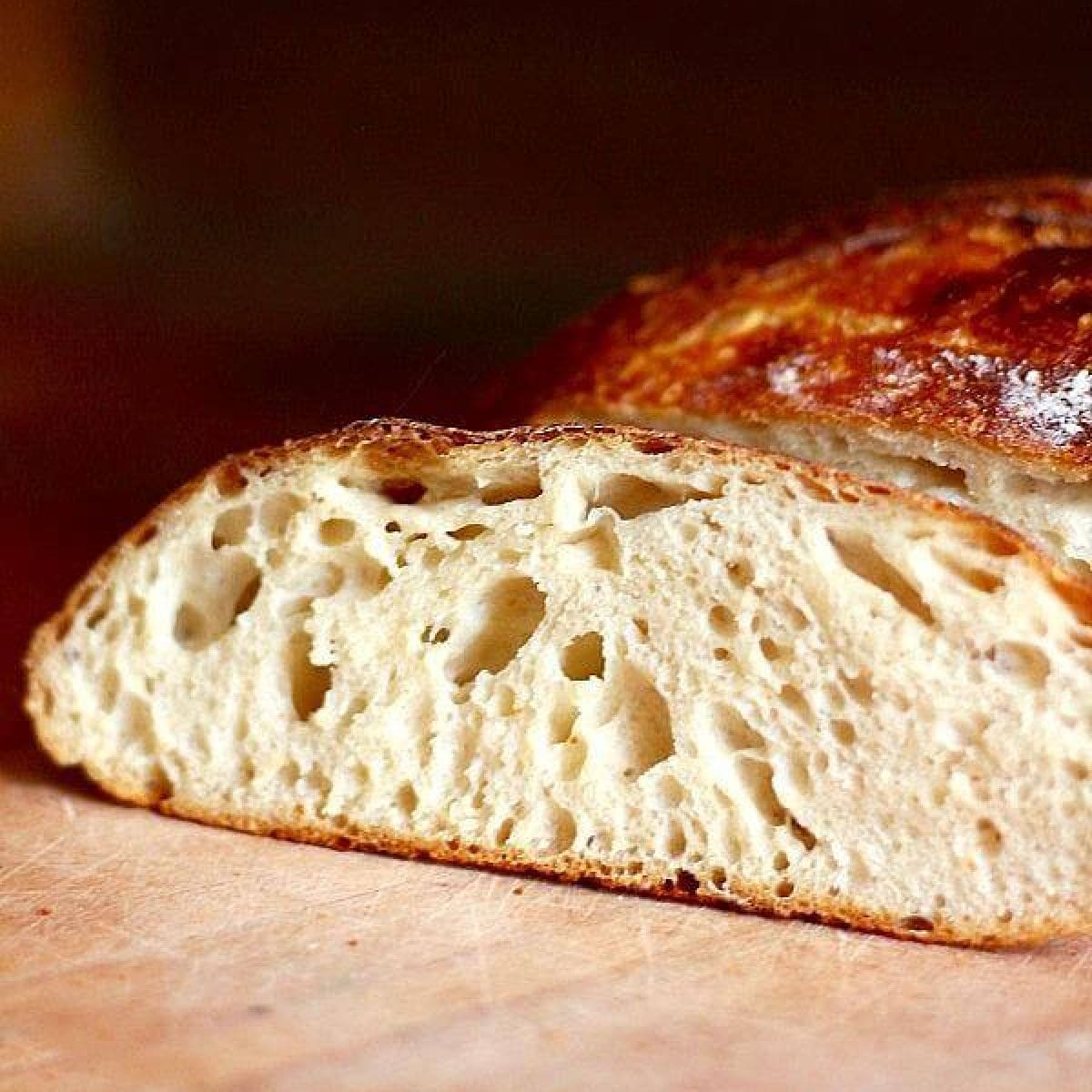 Sliced loaf of sourbread with crispy crust.