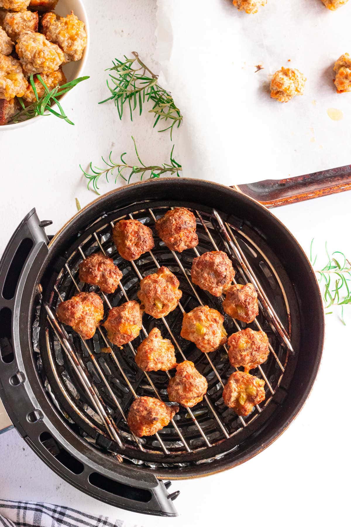 Finished sausage balls on the grill of an air fryer.
