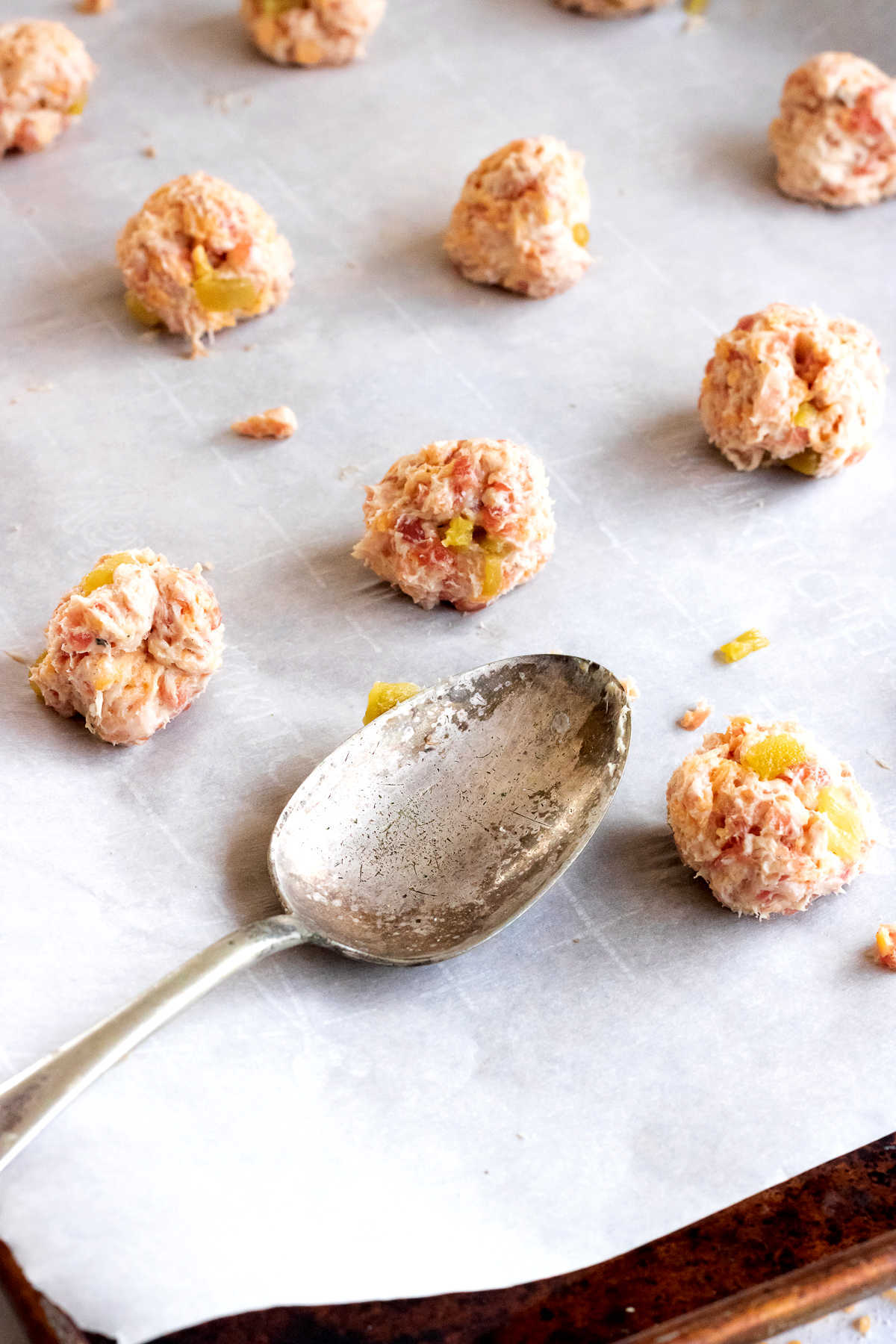 Unbaked sausage balls on a cookie sheet.