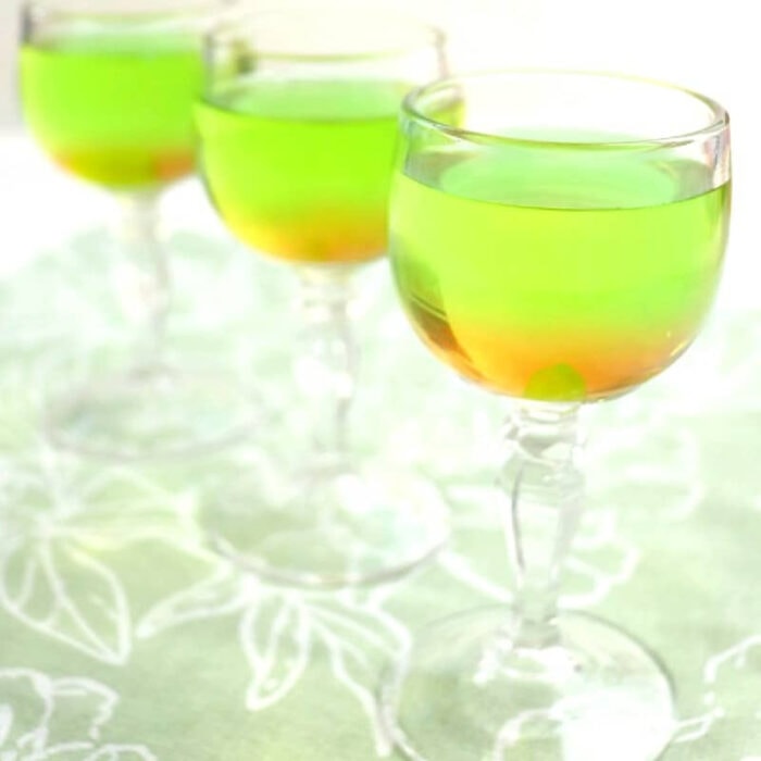 A line of green cocktails in stemmed glasses.
