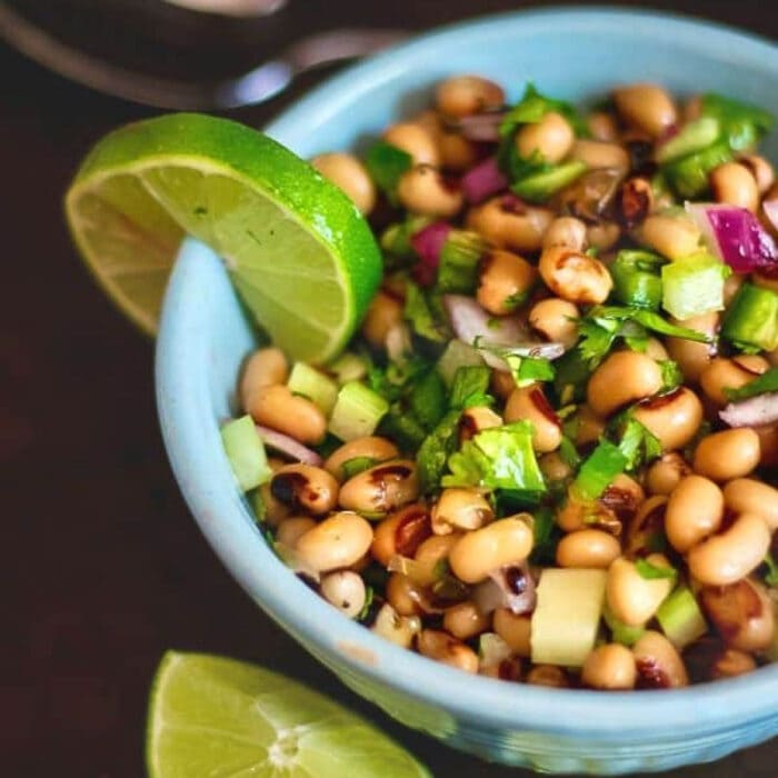 A bowl of. black-eyed peas shown from the top with a lime slice.