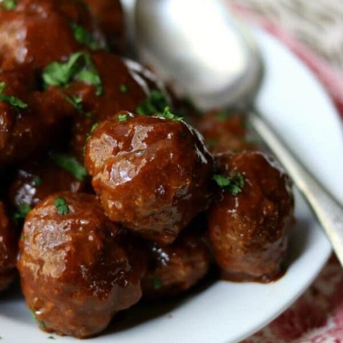 Meatballs glazed with a garlic sauce in a white bowl.