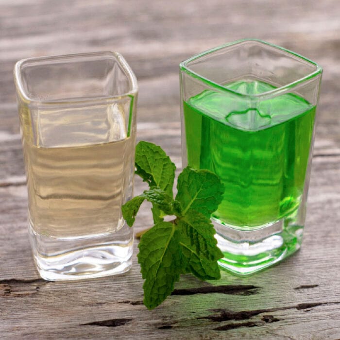 Green creme de menthe in one shot glass and clear in another.