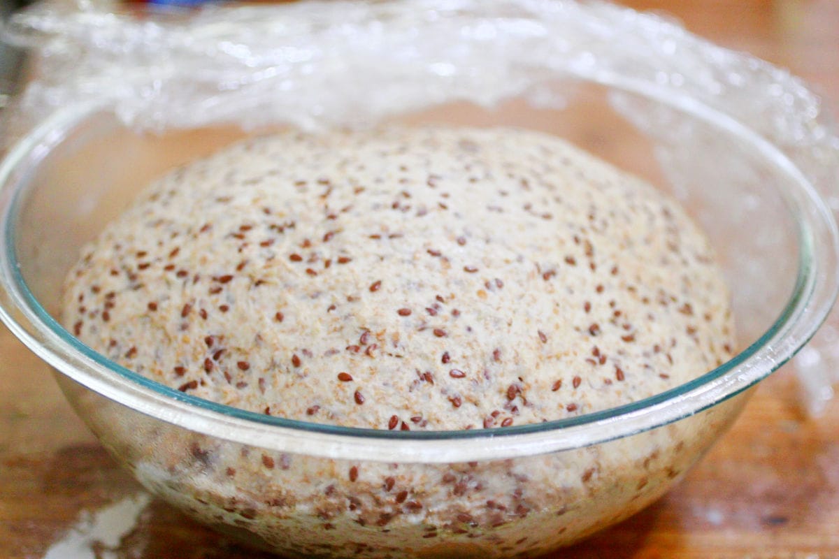 A bowl of flaxseed bread dough rising.