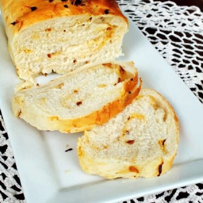 Slices of onion cheese bread on a white plate.