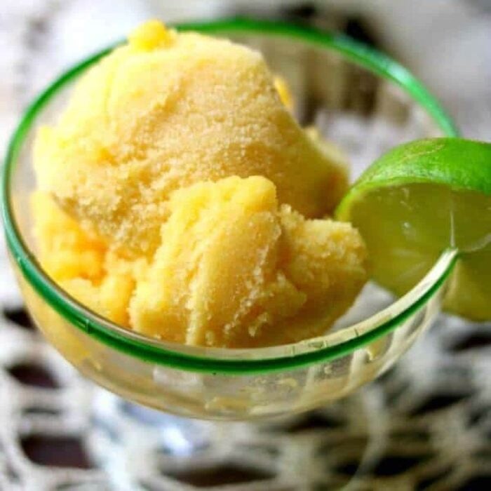 Closeup of ginger peach sorbet in a green serving dish.