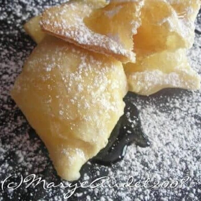 Close up of sopapillas on a black tray.