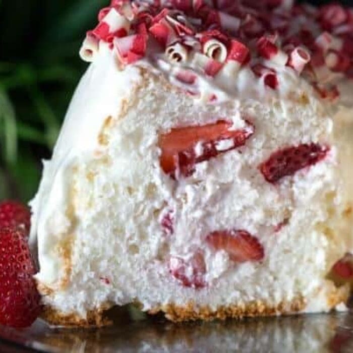 A slice of angel food cake filled with whipped cream and strawberries.