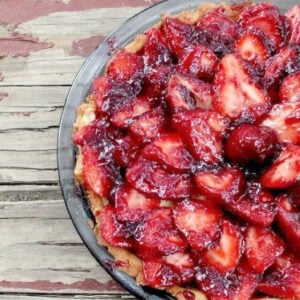 An uncut strawberry tart in a pie dish, seen from the top.