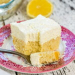 Closeup of a square of lemon cake showing the light texture of the frosting.