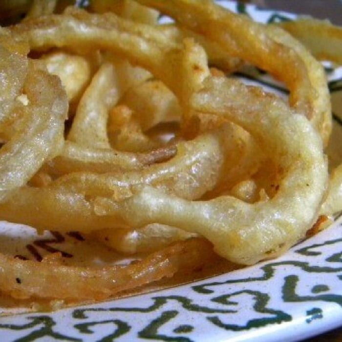 Crispy beer battered onion rings on a plate.