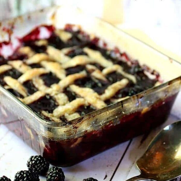 Blackberry cobbler with a lattice crust in a glass dish.