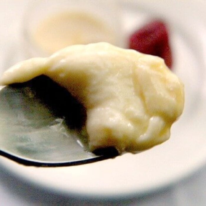 A spoonful of creme caramel being raised from the dish.