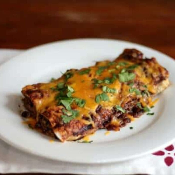 Beef enchiladas on a white plate.