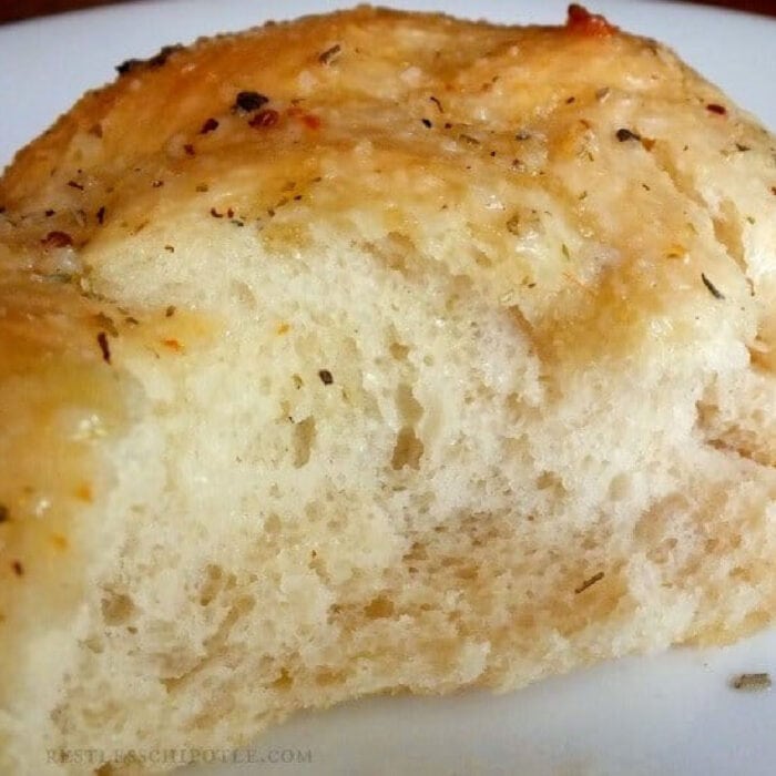 A garlic knot roll cut in half to show texture.