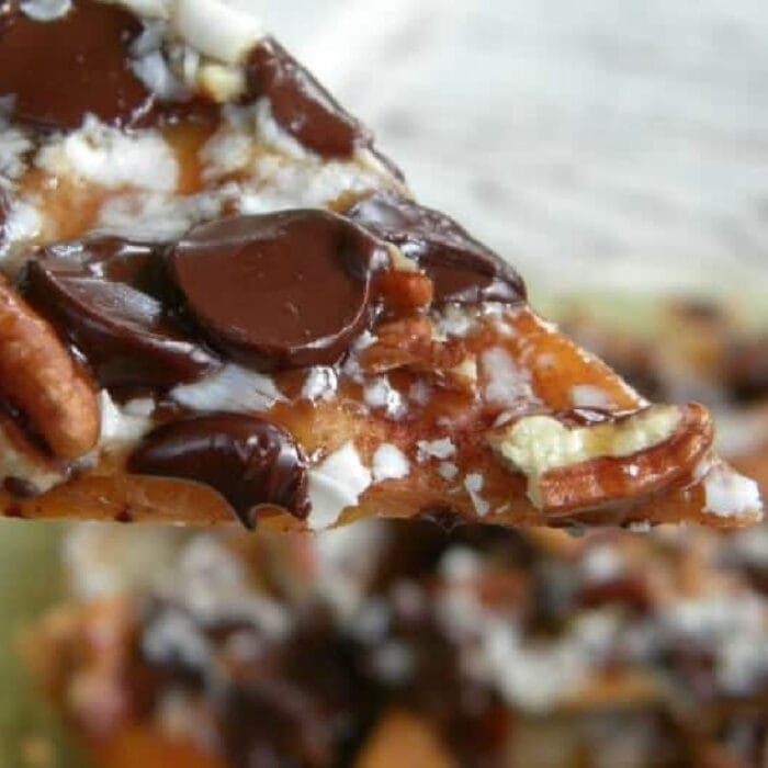 A closeup of a dessert nacho with chocolate chips and pecans.