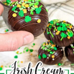 Irish cream hot chocolate bomb being dropped in a cup of hot milk.