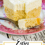 A square of lemon cream cake with a fork next to it. Text overlay for Pinterest.