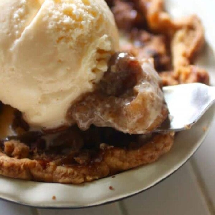 Closeup of an apple bourbon tart with ice cream on top.