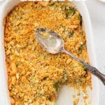 Overhead view of broccoli cheese casserole with a serving spoon on top.Text overlay for Pinterest.