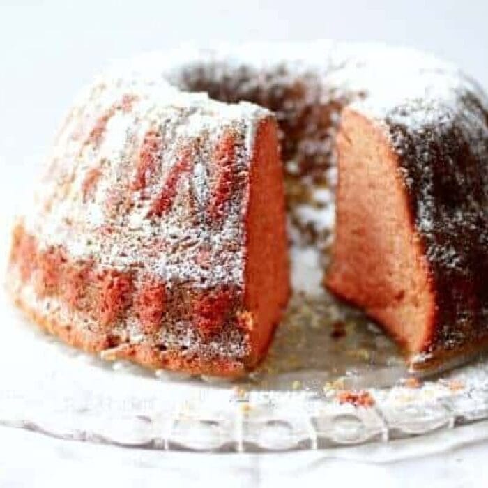 Pink cherry Dr Pepper bundt cake with a slice removed to show the texture.