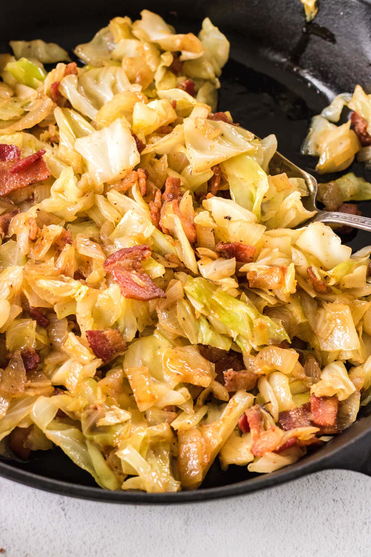 Closeup of this fried cabbage recipe showing the crispy bacon and tender vegetables.