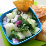 Chips and a refreshing honey dew salsa dip on a table.