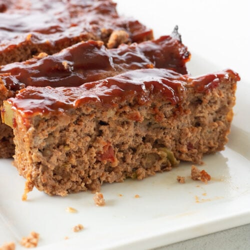 Close up of sliced meatloaf with glaze on top for feature image.