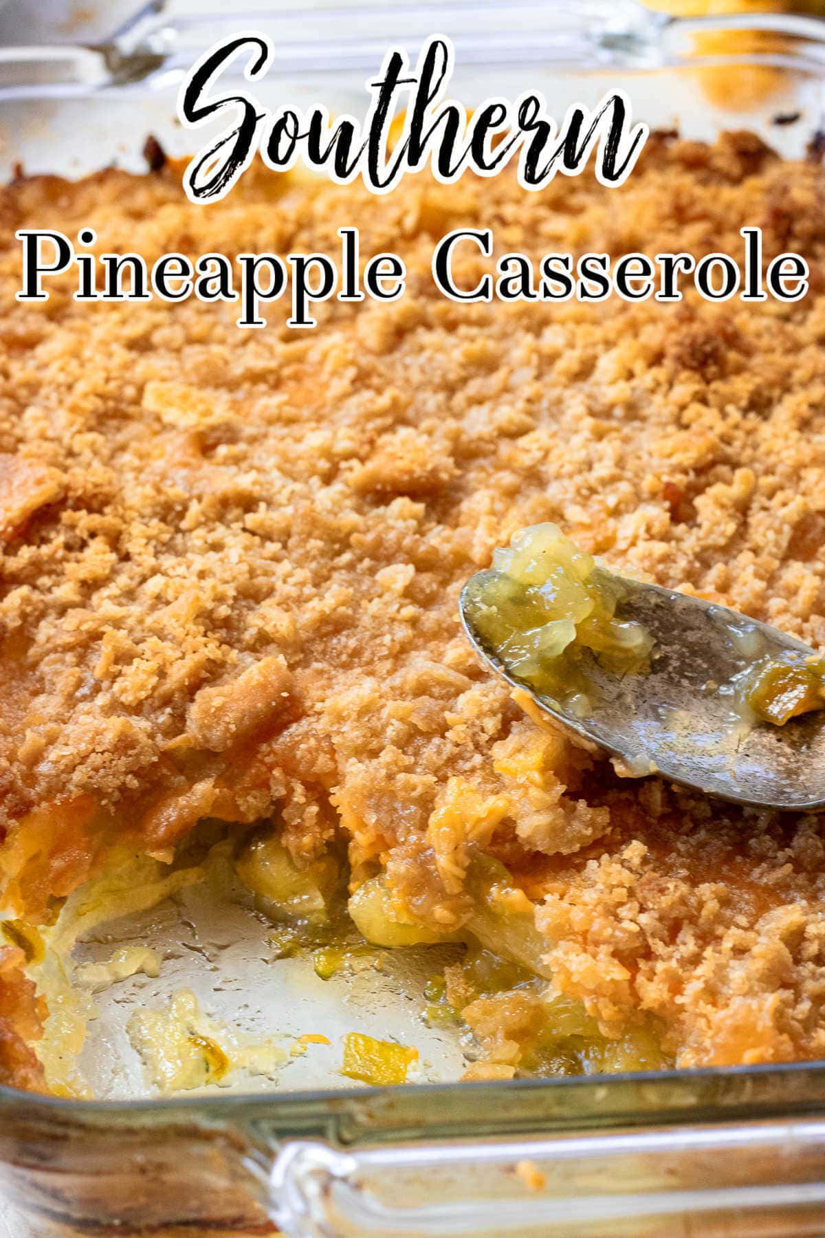 Closeup of pineapple casserole with cheese. A spoon is lying on top.
