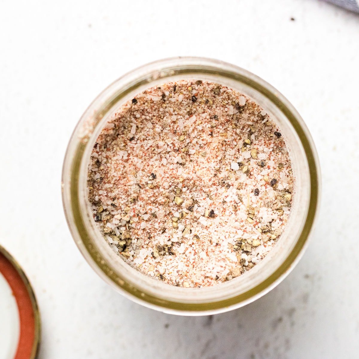 Overhead closeup view of the seasoning in a jar showing texture and color.