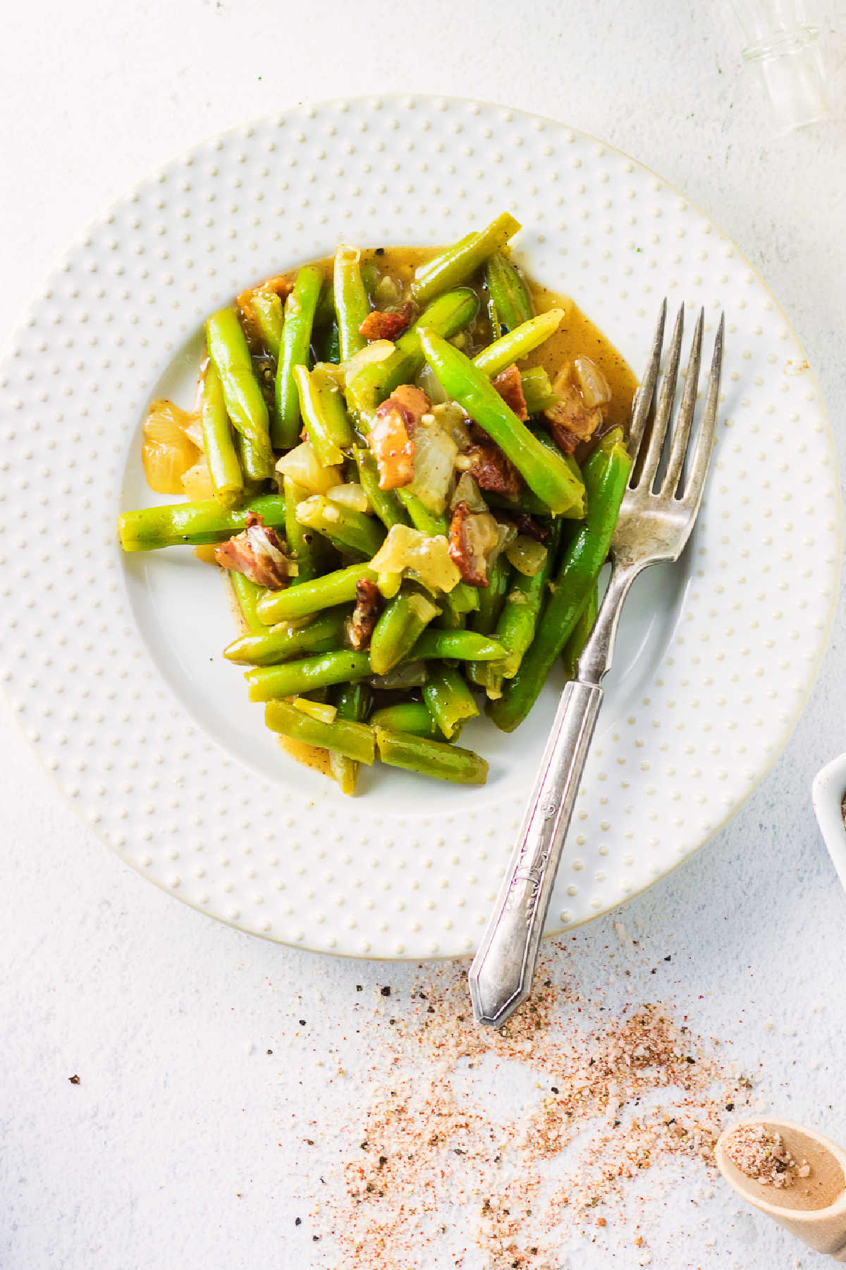 Overhead view of southern green beans on a white plate.