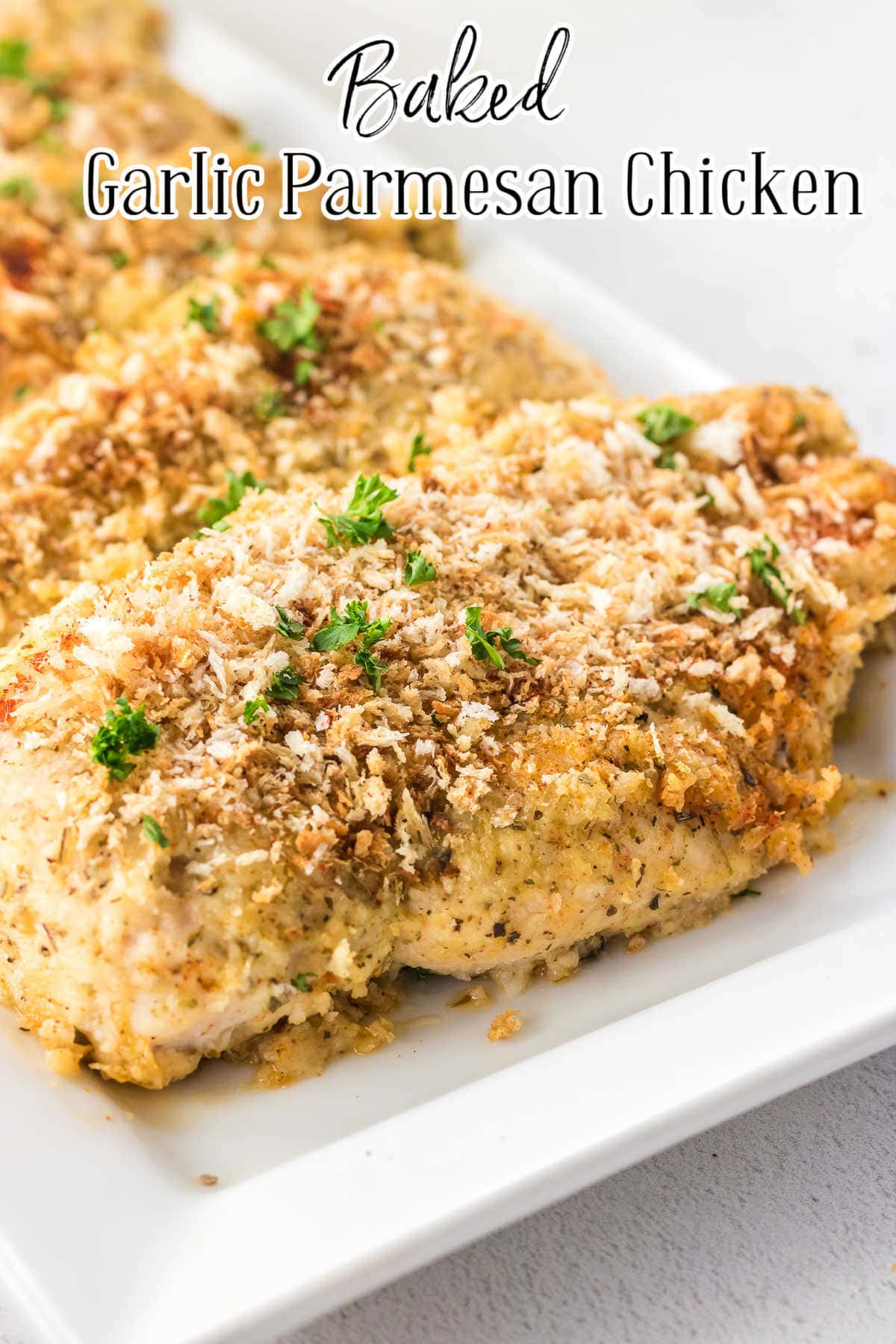 Closeup of breaded chicken breasts on a white plate.