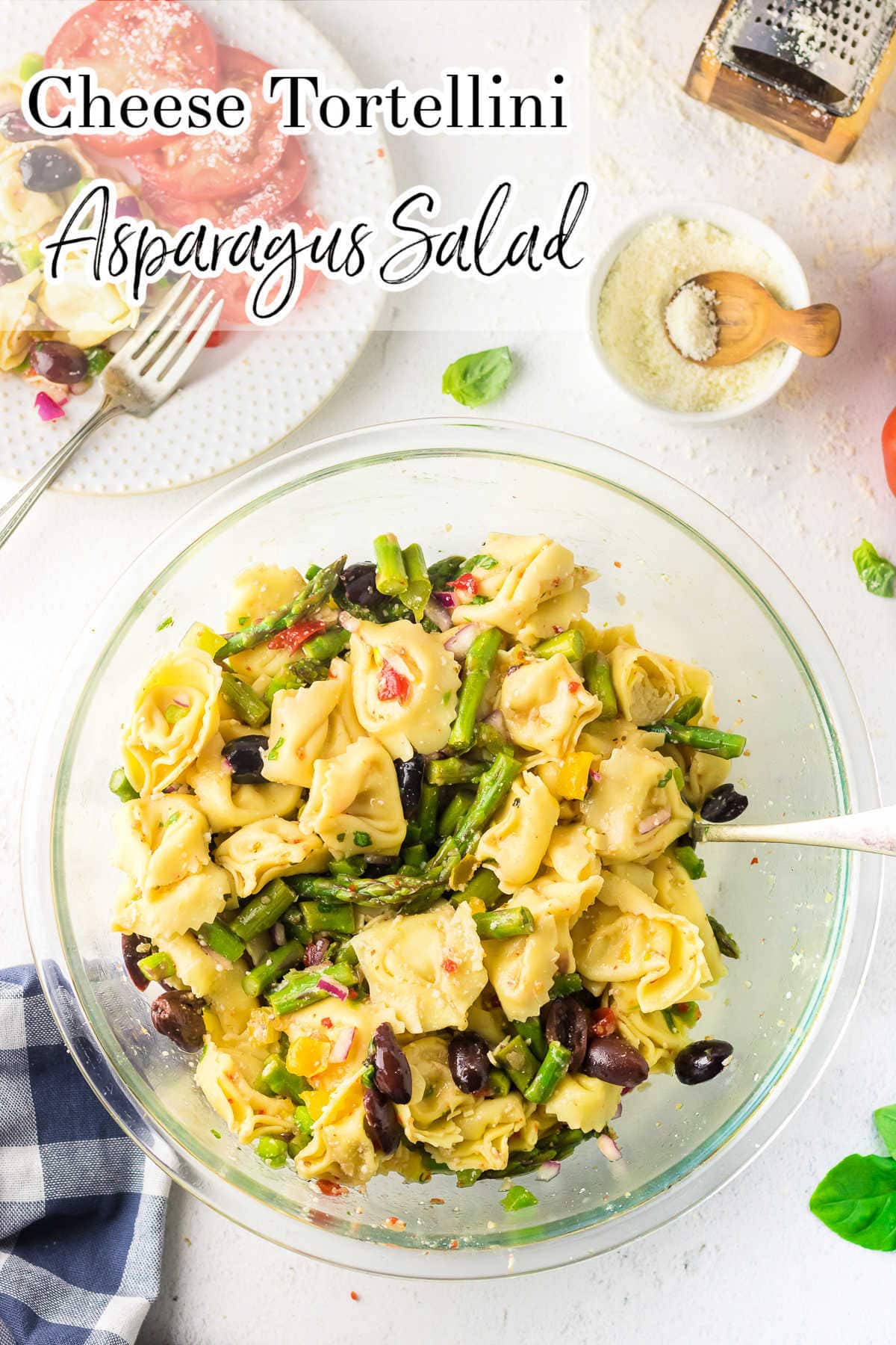 Overhead view of a table with tortellini salad in a bowl in the center. Title text overlay.