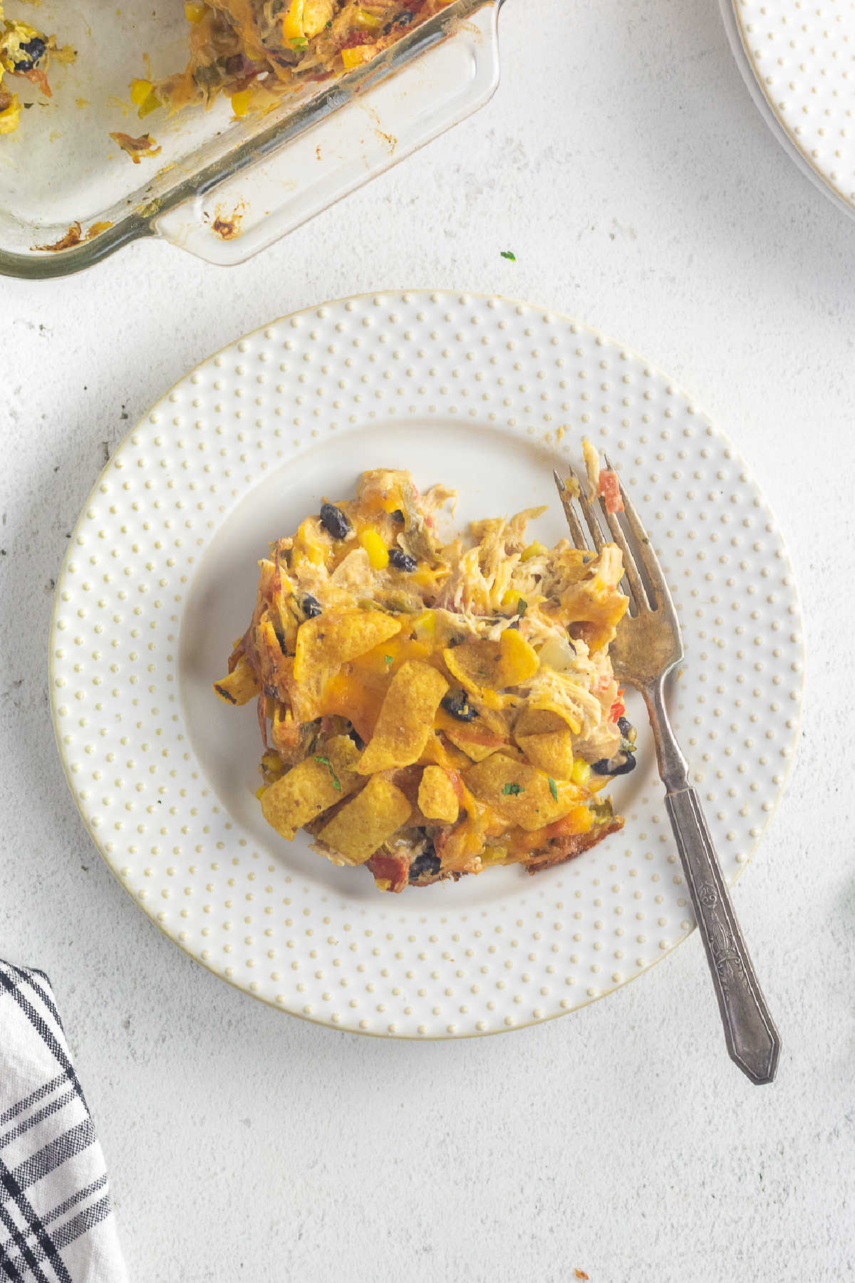 Overhead view of a serving of Frito chicken casserole on a white plate.