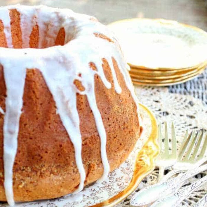 Side view of a margarita bundt cake with a white glaze dripping down the sides.