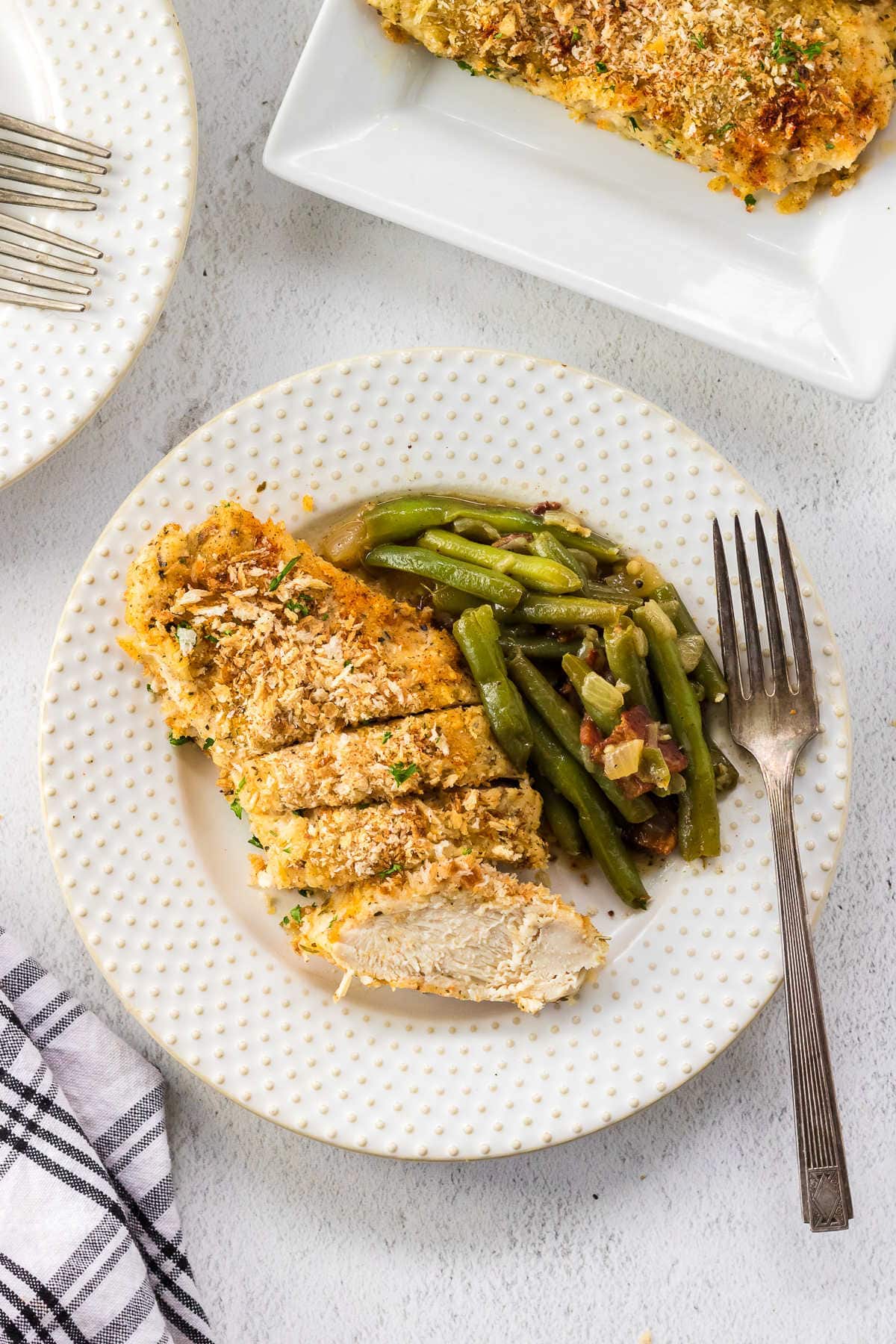 Overhead view of a plate with chicken and green beans in it.