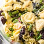 Closeup of tortellini and asparagus salad with a text overlay for Pinterest.