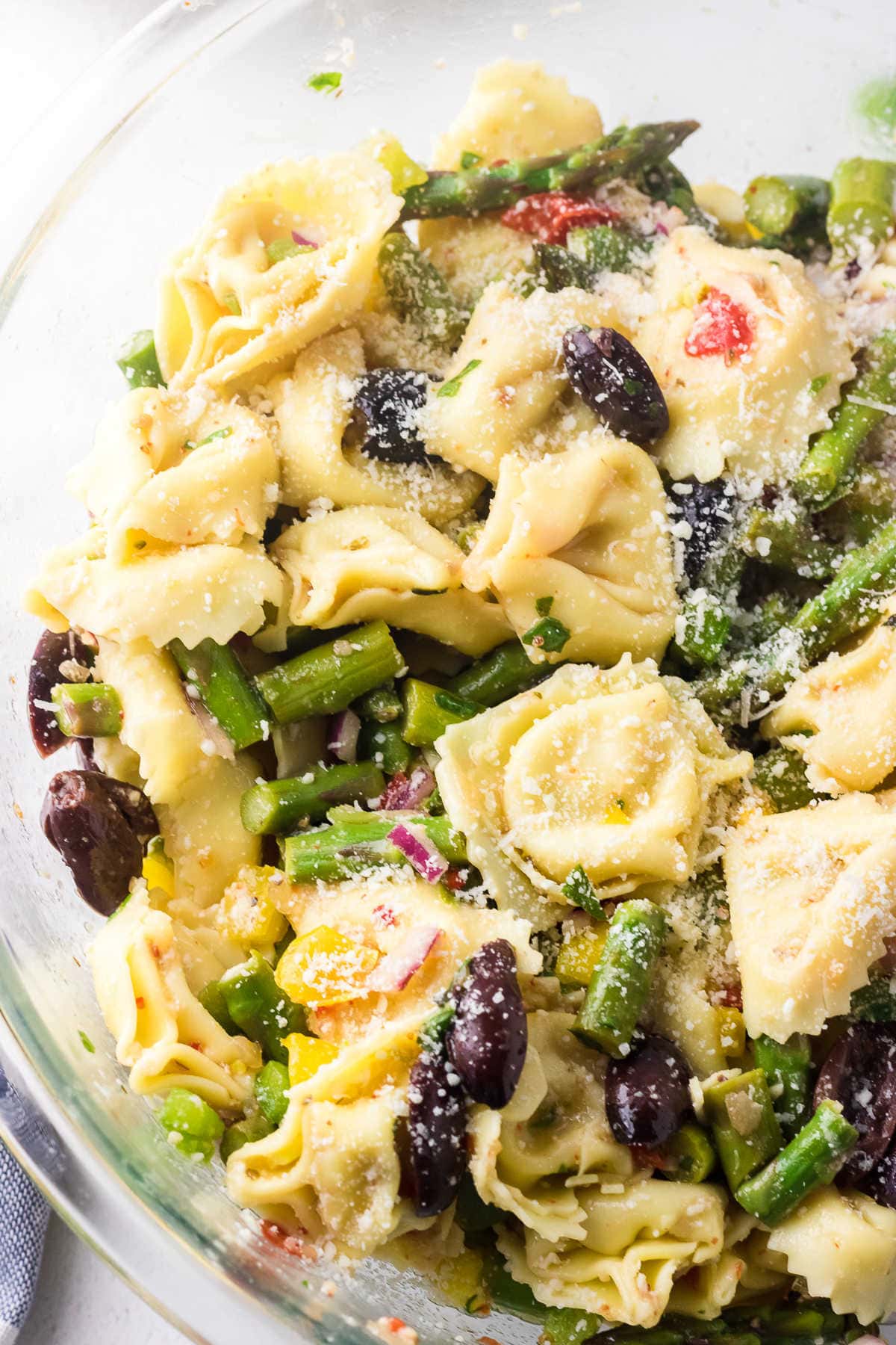 Close up of a bowl of tortellini and asparagus salad.