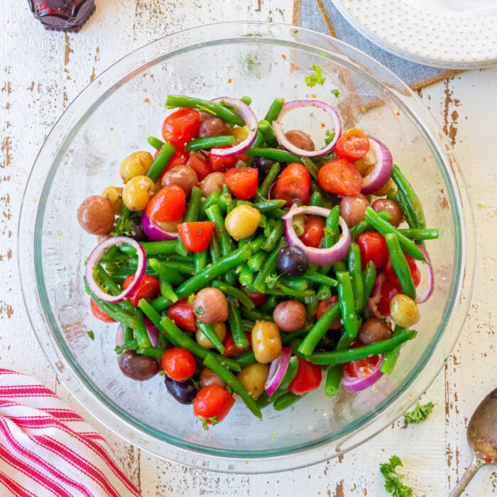 Overhead view of a bowl of green beans, tomatoes, potatoes, and red onions created for the feature image of this post.